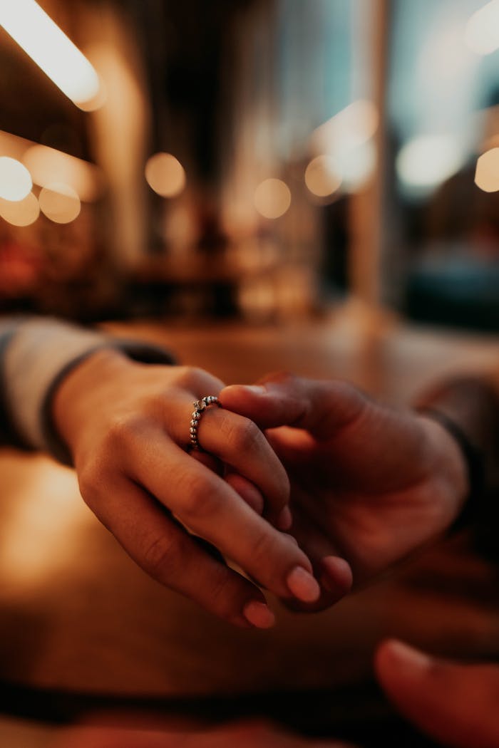 Intimate moment of a couple holding hands in a cozy Buenos Aires café at twilight.